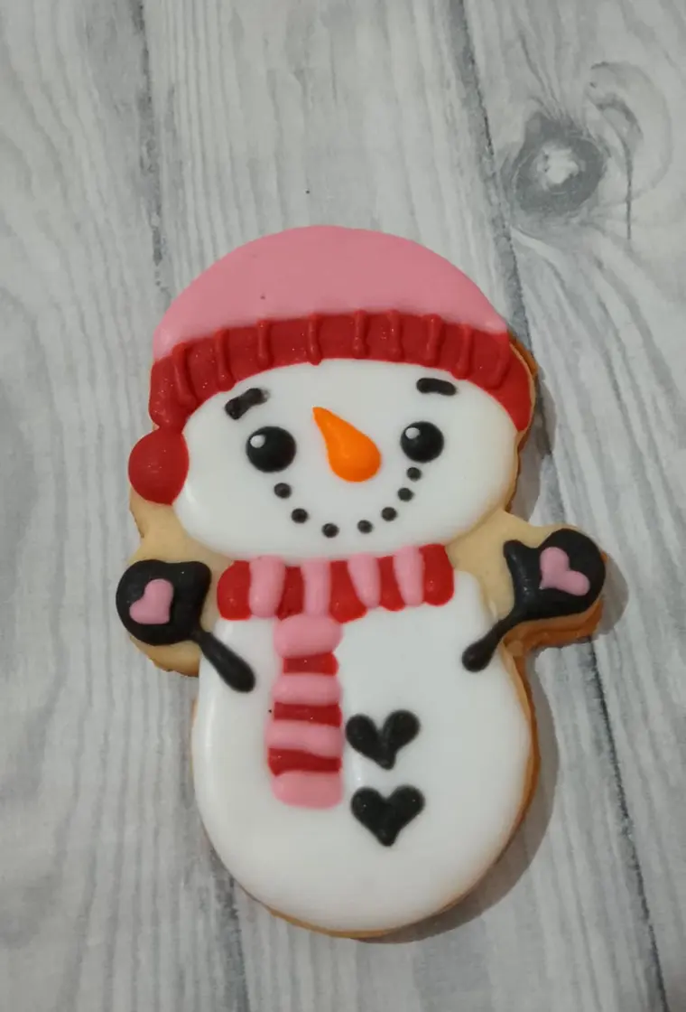 Cookie de muñeco de nieve con detalle en rojo y rosa